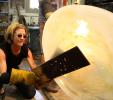 Julie blowing glass in the hotshop furnace